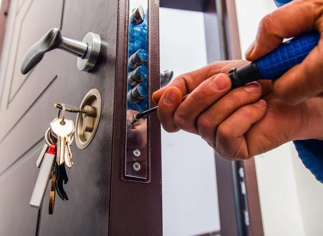 Serrurier professionnel travaillant sur une serrure de porte d'entrée en urgence