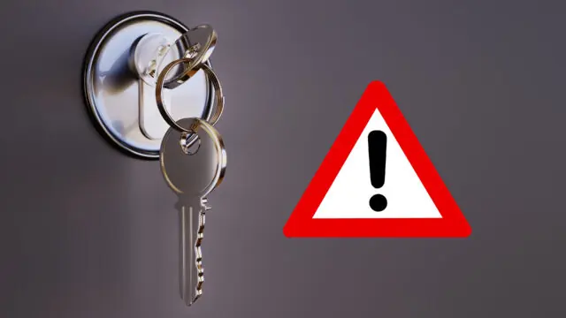 Symbole d'avertissement et clé représentant les arnaques aux serruriers à domicile